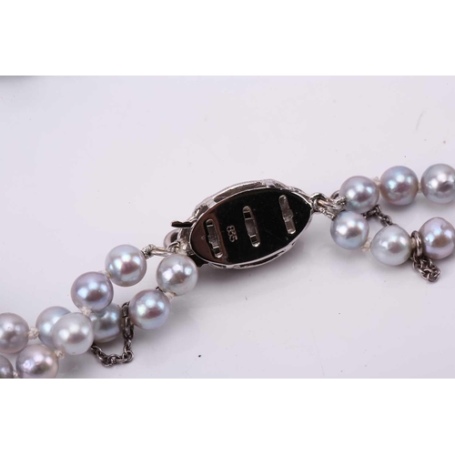 187 - A double strand of slightly graduated pale grey cultured pearls, with a silver and metal clasp, Pear... 