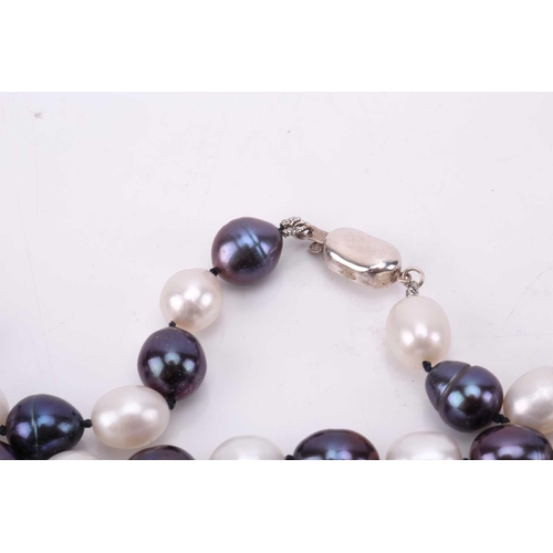 187 - A double strand of slightly graduated pale grey cultured pearls, with a silver and metal clasp, Pear... 