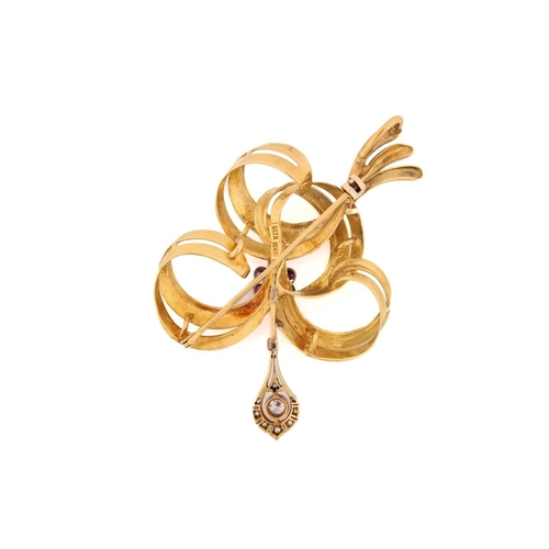 194 - A gem-set bow brooch in 18ct gold, of ribbon form with Florentine finish, embellished with a ruby cl... 