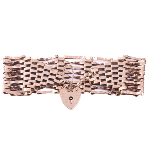 209 - A gate bracelet, formed of a wide mesh of plain and twisted links, measuring 26mm wide with a length... 