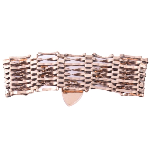 209 - A gate bracelet, formed of a wide mesh of plain and twisted links, measuring 26mm wide with a length... 