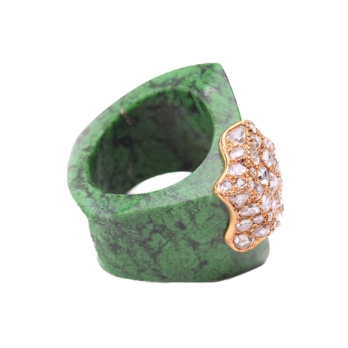 222 - A carved maw-sit-sit archer ring set with diamonds, the stylised ring adorned with a splatter motif ... 