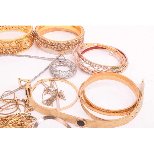 225 - A collection of base metal costume jewellery including Indian style bangles, including hinged exampl... 