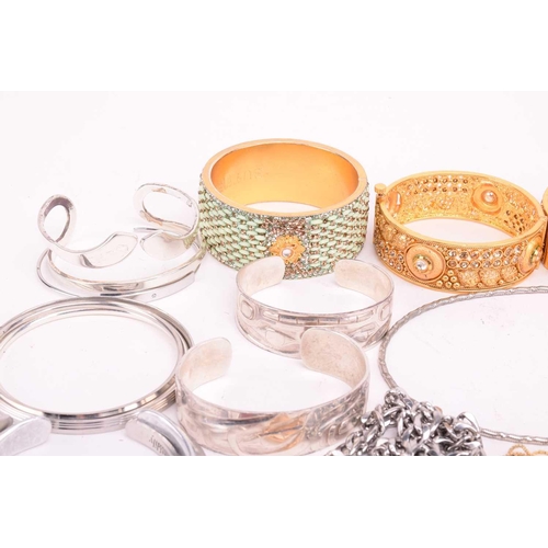 225 - A collection of base metal costume jewellery including Indian style bangles, including hinged exampl... 