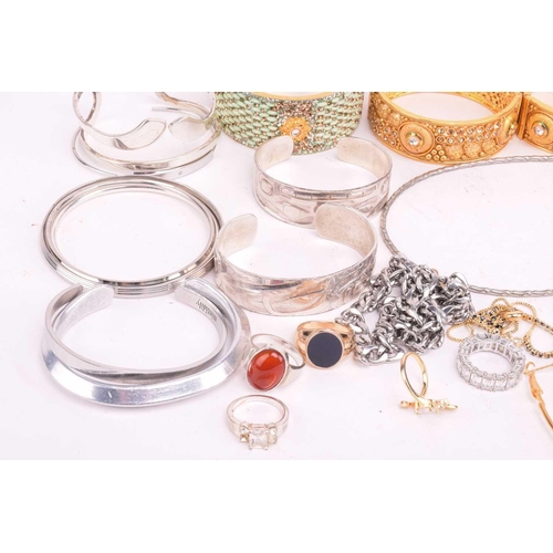 225 - A collection of base metal costume jewellery including Indian style bangles, including hinged exampl... 