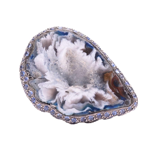 228 - A quartz geode ring of pear form, the black rhodium setting encrusted with round mixed cut sapphires... 