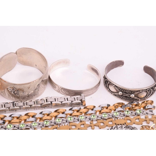 231 - A quantity of base metal costume jewellery comprising a collection of bangles including hinged examp... 