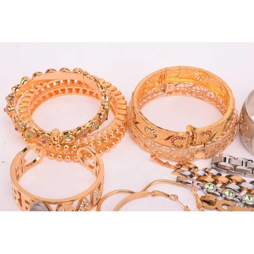 231 - A quantity of base metal costume jewellery comprising a collection of bangles including hinged examp... 