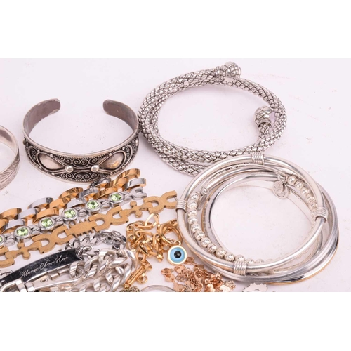 231 - A quantity of base metal costume jewellery comprising a collection of bangles including hinged examp... 