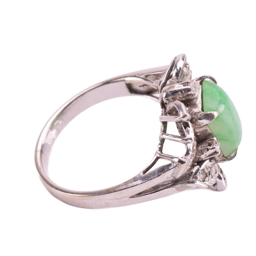 237 - A jade and diamond ring, set with a central sugarloaf cabochon jade measuring 9.4 x 7.5mm, within a ... 