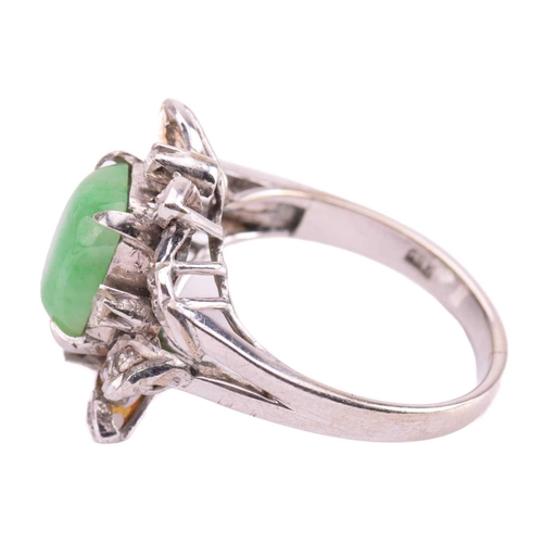 237 - A jade and diamond ring, set with a central sugarloaf cabochon jade measuring 9.4 x 7.5mm, within a ... 