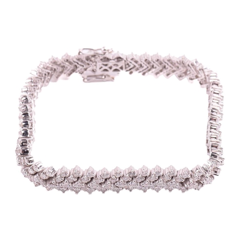 245 - A diamond chevron line bracelet, set with round brilliant cut diamonds in a repeating chevron design... 