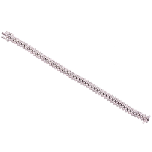 245 - A diamond chevron line bracelet, set with round brilliant cut diamonds in a repeating chevron design... 