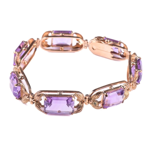 250 - A link bracelet set with seven graduated amethysts, each openwork oblong link claw-set with an emera... 