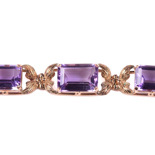 250 - A link bracelet set with seven graduated amethysts, each openwork oblong link claw-set with an emera... 