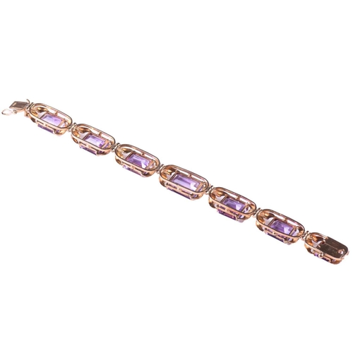 250 - A link bracelet set with seven graduated amethysts, each openwork oblong link claw-set with an emera... 