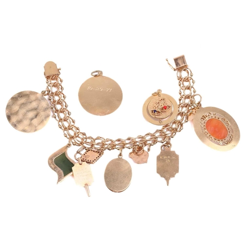 261 - A charm bracelet with a variety of charms including a shell cameo, a nephrite charm, and four set wi... 