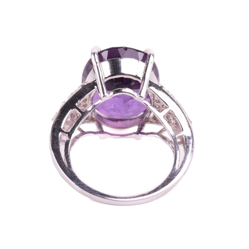 29 - A large amethyst and diamond cocktail ring, featuring an oval-cut amethyst in deep purple colour, ap... 