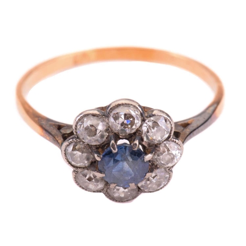 285 - A sapphire and diamond cluster ring, the central sapphire measuring 4.7mm diameter, encircled by old... 