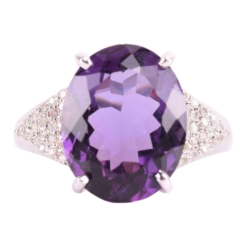 29 - A large amethyst and diamond cocktail ring, featuring an oval-cut amethyst in deep purple colour, ap... 