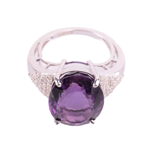 29 - A large amethyst and diamond cocktail ring, featuring an oval-cut amethyst in deep purple colour, ap... 