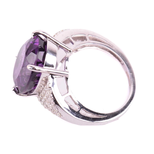 29 - A large amethyst and diamond cocktail ring, featuring an oval-cut amethyst in deep purple colour, ap... 