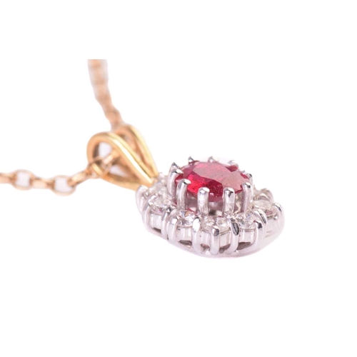 303 - A ruby and diamond cluster pendant, the central ruby measuring 5.7 x 5.2mm, encircled by round brill... 