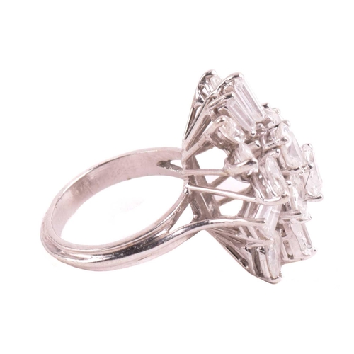 319 - A diamond cluster ring, set with an array of oval, marquise, pear shape, and tapered baguette cut di... 