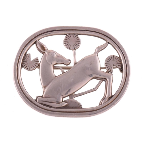 330 - Georg Jensen - a brooch depicting a kneeling fawn and flowers, fitted with a hinged pin stem and rol... 