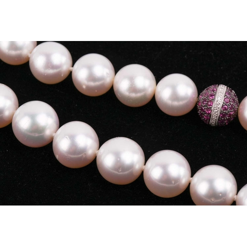 42 - A South Sea pearl necklace with a spherical diamond and pink sapphire clasp, the pearls measuring 13... 