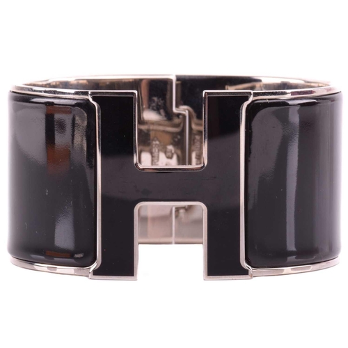 44 - Hermès - an extra wide 'Clic Clac H' bracelet with black enamel and white-toned metal, signed and ma... 