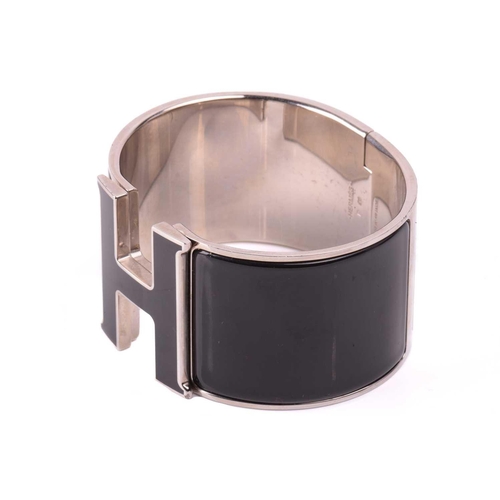 44 - Hermès - an extra wide 'Clic Clac H' bracelet with black enamel and white-toned metal, signed and ma... 