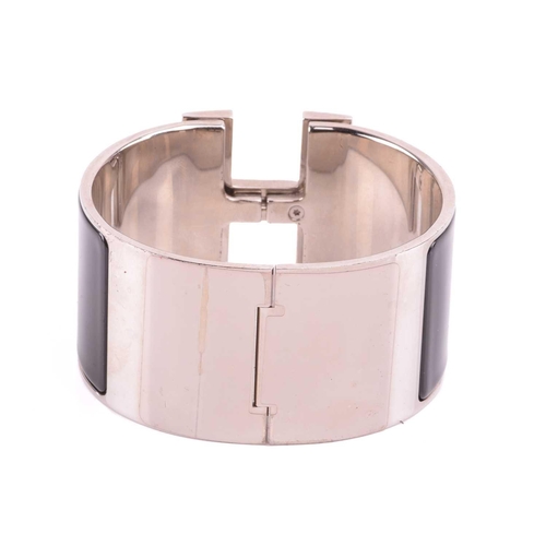 44 - Hermès - an extra wide 'Clic Clac H' bracelet with black enamel and white-toned metal, signed and ma... 