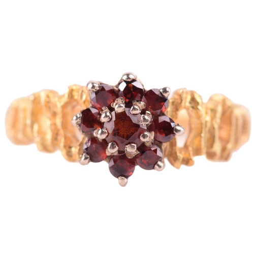 38 - A garnet cluster ring, with textured shoulders leading to the shank marked 18ct, ring size L 1/2, a ... 