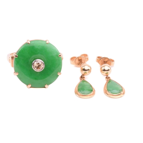 64 - A jade and diamond dress ring; the circular jadeite bi disc of bright green colour, set with a centr... 