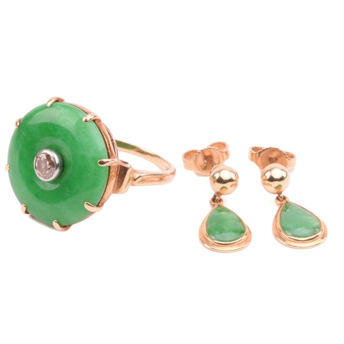 64 - A jade and diamond dress ring; the circular jadeite bi disc of bright green colour, set with a centr... 