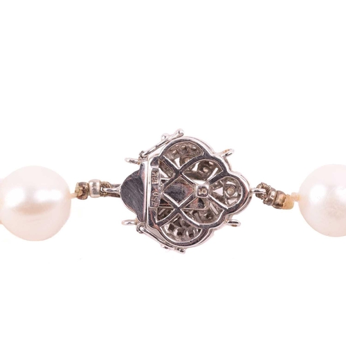 73 - A single-strand cultured pearl necklace with gem-set clasp, containing a uniform row of off-round cu... 