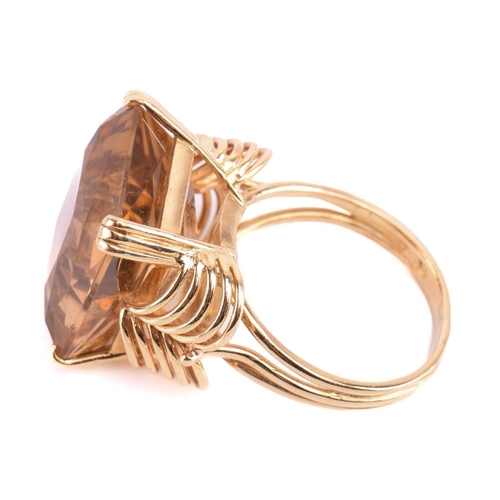 75 - A single stone citrine dress ring, the large rectangular mixed cut, cut-cornered citrine in ribbed c... 