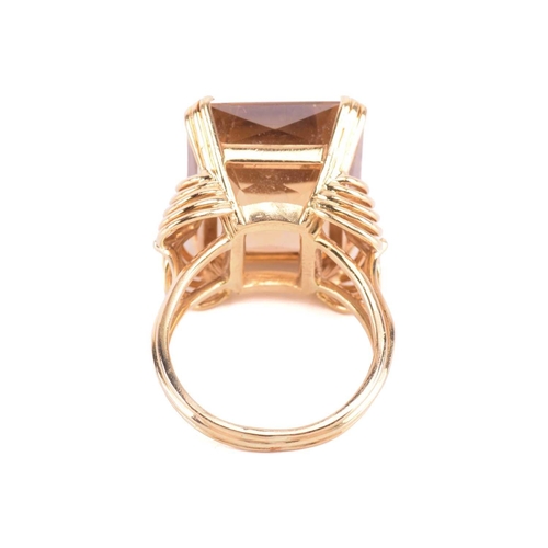 75 - A single stone citrine dress ring, the large rectangular mixed cut, cut-cornered citrine in ribbed c... 