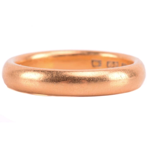 86 - A wedding band in 22ct yellow gold, constructed of a heavy court-profile band, London hallmarked, 19... 