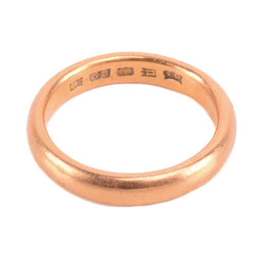 86 - A wedding band in 22ct yellow gold, constructed of a heavy court-profile band, London hallmarked, 19... 