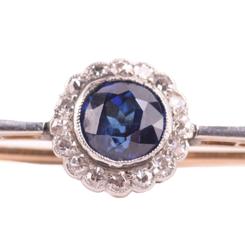 90 - A sapphire and diamond cluster bar brooch, set with a central round sapphire measuring 6mm in diamet... 