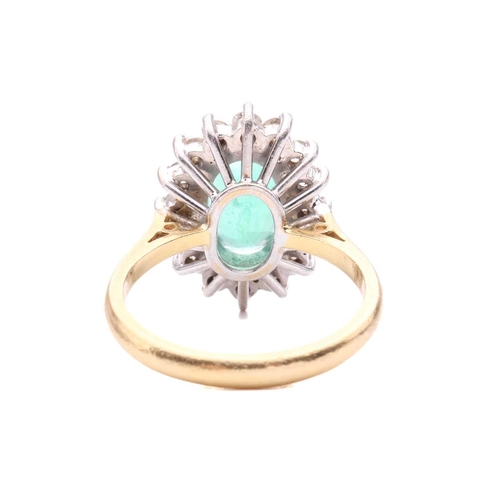 107 - An emerald and diamond cluster ring, the oval mixed cut emerald measuring 11.4 x 7.3 x 3.7mm, within... 