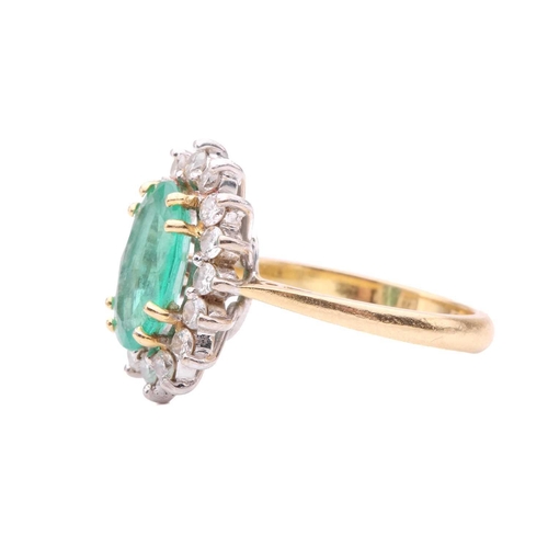 107 - An emerald and diamond cluster ring, the oval mixed cut emerald measuring 11.4 x 7.3 x 3.7mm, within... 