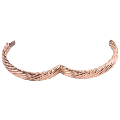 111 - A hinged bangle in twisted rope design, the hollow halves are hinged and fastened together with a co... 