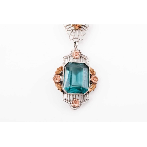 112 - An American fine pendant necklace, the pendant set with a blue-green paste within a dainty tri-colou... 