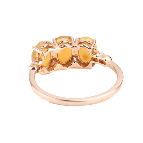 114 - A fire opal trilogy ring in 9ct gold, claw-set with three oval-cut Welo precious fire opals, with st... 