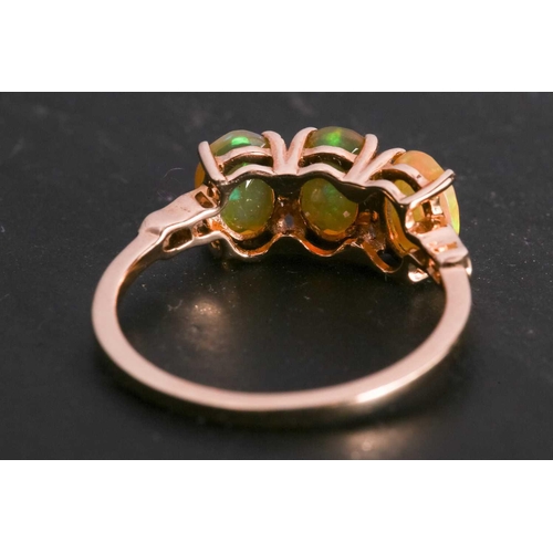 114 - A fire opal trilogy ring in 9ct gold, claw-set with three oval-cut Welo precious fire opals, with st... 