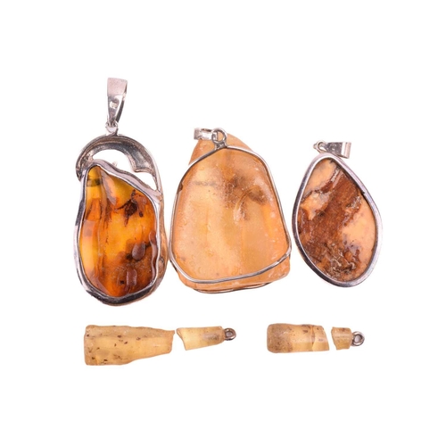 19 - A collection of five amber and copal resin pendants, including a butterscotch amber pendant measurin... 