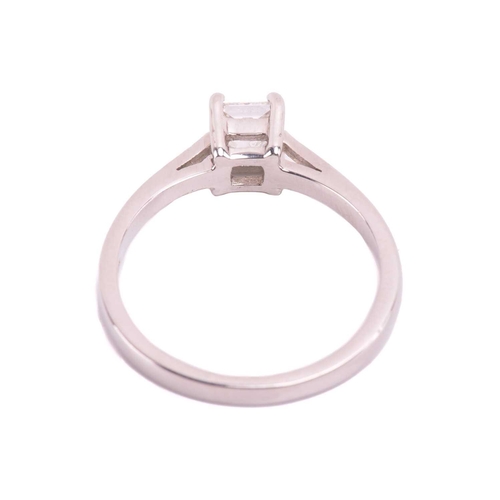 23 - A single stone diamond ring; the princess diamond in four claw mount, to tapered shoulders and plain... 